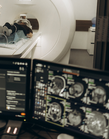 A patient is lying on a table in an MRI machine and getting an MRI scan at a diagnostic imaging center