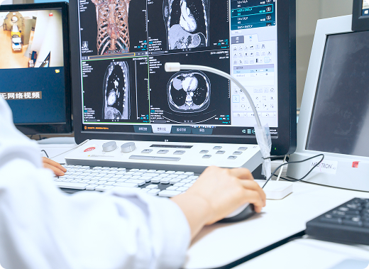 Un radiólogo revisa los resultados de las imágenes de resonancia magnética en una computadora en su escritorio