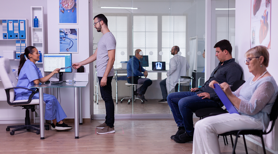 Patients sit, fill out forms, and talk to radiology staff members in a waiting room at a medical imaging center in Houston, Texas