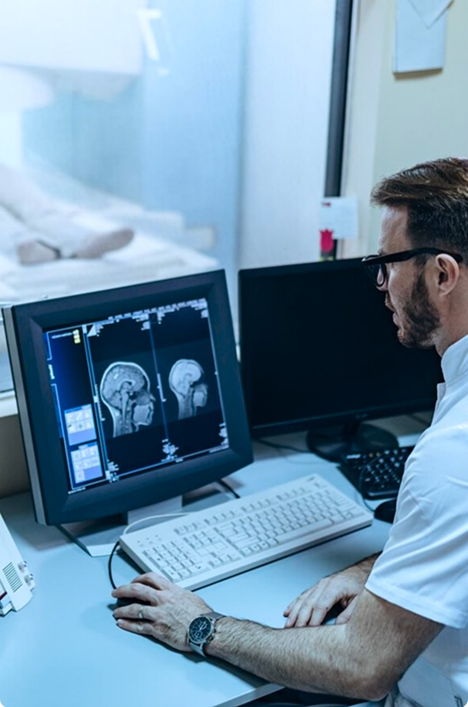 doctors-hand-holding-ultrasound-transducers A radiology technician watches the live results of an MRI scan while a patient moves through an MRI machine in the next room
