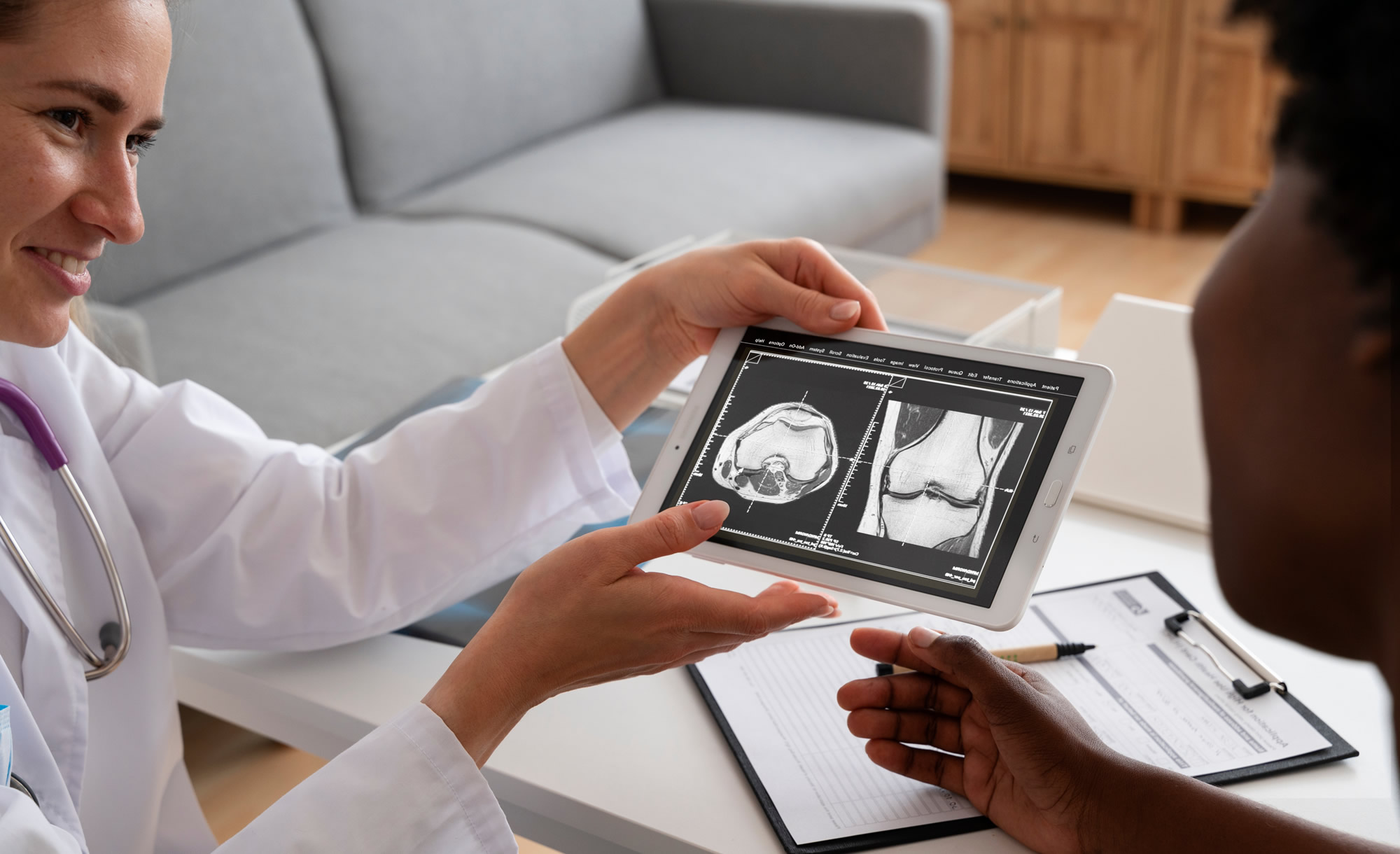 A radiologist shows their patient a tablet with X-rays and discusses the results of their medical diagnostic imaging exam