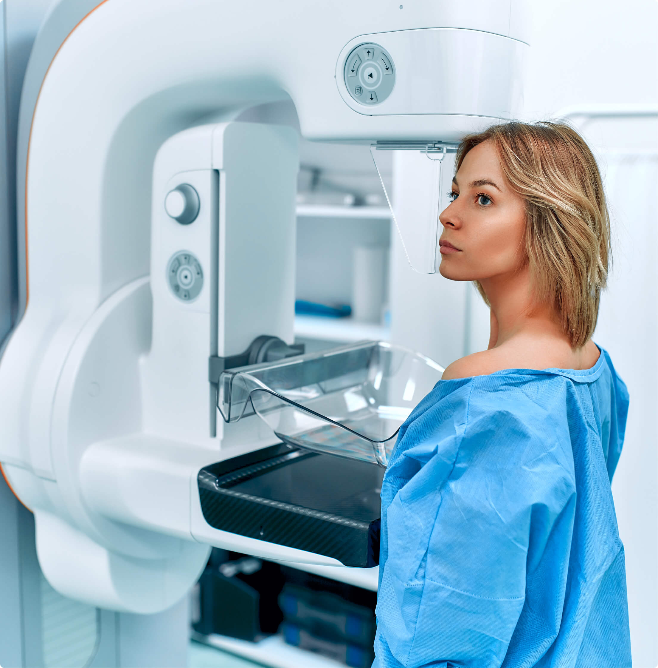 Una paciente se encuentra frente a una máquina de mamografía y se realiza un examen en un centro de diagnóstico por imágenes