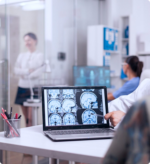 senior-woman-hospital-office-looking-brain-ct-scan-while-discussing-with-doctor-about-diagnosis-sick-young-woman-elderly-medic-with-grey-hair-clinic-corridor_482257-9563 A patient and their radiologist sit at a desk and review the diagnostic imaging results from their patient portal on a laptop